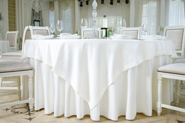 a table with a white tablecloth and glasses on it
