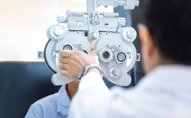 Optometrist doing sight testing for child patient in clinic, Kid boy doing eye test checking...