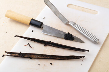 Raw vanilla on chopping board with Japanese knife. Food culture. Healthy food with no flavouring...