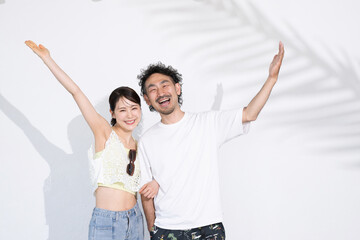 Japanese (Asian) couple with suitcases going on a summer vacation, traveling abroad or on honeymoon, honeymoon or going to a tropical country Image: Looking at the camera