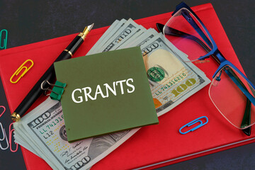 Business concept. Concept word grants on a sticker on the background of a business notebook and...