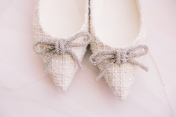 A pair of pretty wedding shoes with a bow that is sparkly