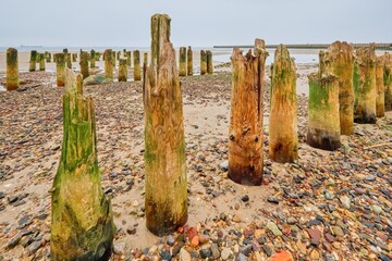 Ruined wooden pier leading towards the sea on the horizon.