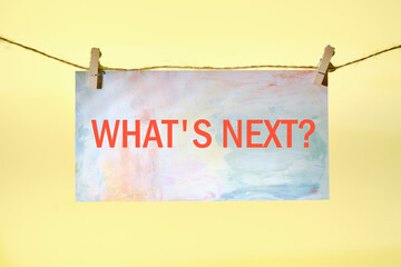 Business concept. What is next written on paper suspended from a rope on a yellow background