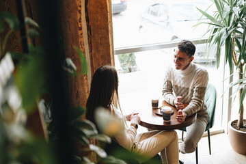 Man and Woman Sitting at Table Talking