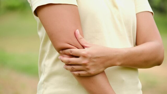 A woman has pain in his elbow and tendon muscles and he relieves the pain with a massage. Health and healing concept	