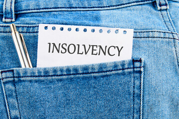 Debt relief concept. A word INSOLVENCY on a piece of paper that appeared from the pocket of jeans