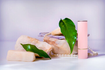 Cosmetic packaging, product on marble stone podium, decoration pearls and fresh plants. Lipstick...