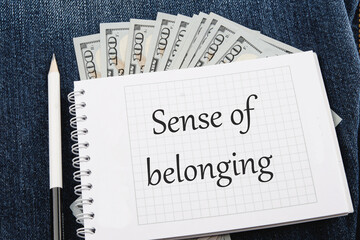 Business, sense of belonging concept. Text Sense of belonging on a notebook lying on jeans with...