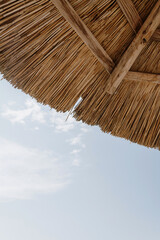 Beautiful lounge pavilion canopy umbrella and blue sky. Umbrella made of dry bamboo. Luxury summer...