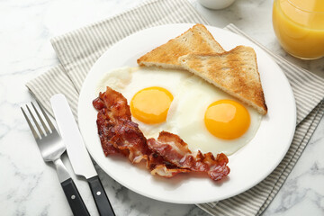 Delicious breakfast with sunny side up eggs served on white marble table, closeup