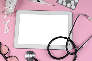 Flat lay composition with modern tablet and medical supplies on pink background
