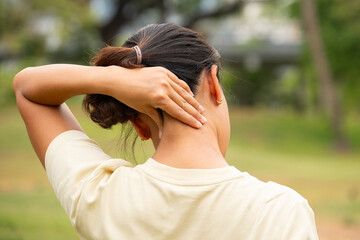 Women have neck pain, shoulder pain, at the park health concept.	
