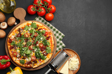Delicious vegetarian pizza, ingredients and grater on black table, flat lay. Space for text