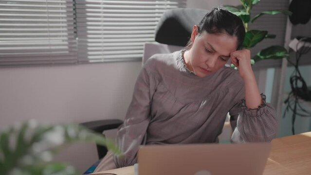Stressed woman working at dawn Woman full of fatigue while using computer in empty office overworked