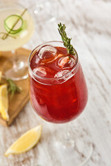 Refreshing Pomegranate Cocktail with Rosemary on Rustic Wooden Table, Daytime Setting