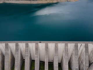 water dam in Alps, view from above with copyspace, car driving on top of water dam