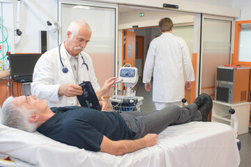 Obraz premium male doctor measuring the blood pressure of a senior man