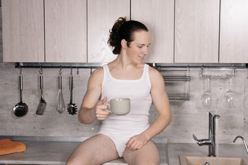 A young attractive man is preparing breakfast in his kitchen.