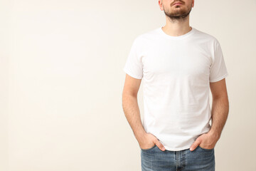 A young guy in a white T-shirt on a light background