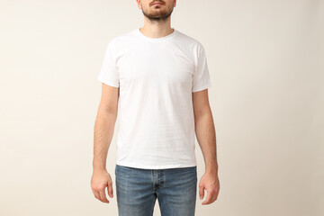 A young guy in a white T-shirt on a light background
