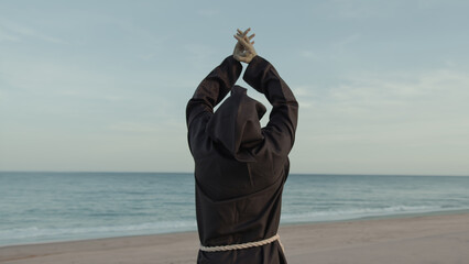 Religious Monk With Prays Towards The Sea With Open Arms