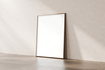 Blank frame with a wooden border leaning against a beige wall on a wooden floor, with ample empty...