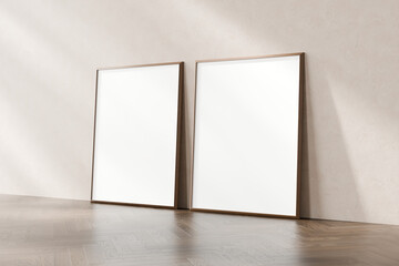 Two empty wooden picture frames lean against a clean wall on a wooden floor, implying space for art...