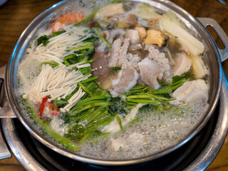A person is cooking a dish with a spoon in a pan