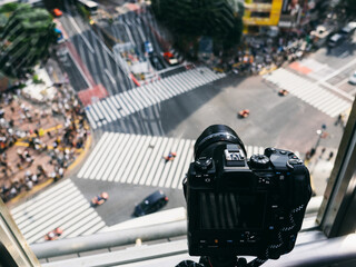 A camera is pointed at a busy intersection with cars and people. The camera is focused on the...