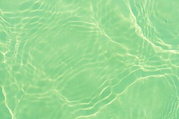 Blue water with ripples on the surface. Defocus blurred transparent blue colored clear calm water surface texture with splashes and bubbles. Water waves with shining pattern texture background.