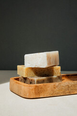 Handmade soap from natural ingredients, various herbs. Concept of sustainable use, bath products on wooden tray. Front view