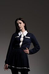 Portrait of attractive caucasian young brunette woman in school uniform in studio. Elegant woman posing. Pretty stylish model. Beauty, Style, Fashion, Luxury