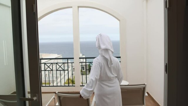 Woman in Bathrobe Enjoying Ocean View from Balcony