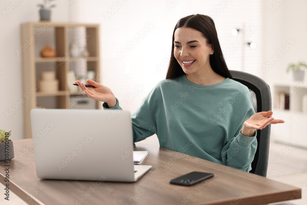 Sticker Young woman using video chat during webinar at table in room