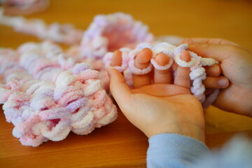10歳 小学4年生の女の子が指編みで編み物をしている手元の様子。