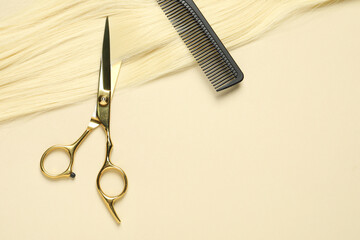 Professional scissors and comb with blonde hair strand on beige background, top view. Space for text