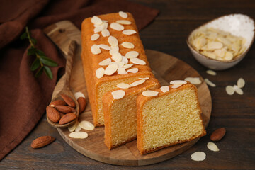 Cake with fresh almond flakes on wooden table, closeup