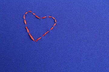 Embroidered heart on blue cloth, top view