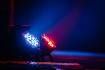stage lights emitting blue and red beams in a dark setting, highlighting the dramatic effects of...