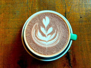 A cup of coffee on a wooden table. Coffee break. Drawing on coffee
