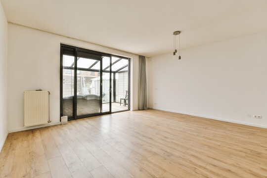 Modern empty living room with large sliding door to terrace