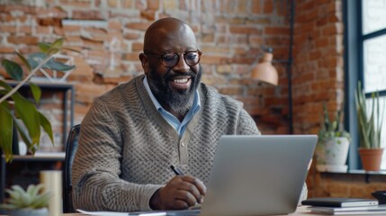 Fototapeta premium Smiling Man Working on Laptop