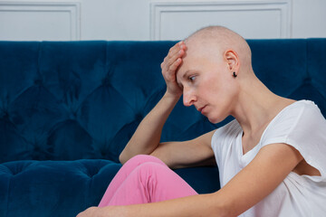 Woman with shaved head sit sadly struggle of chemo side effects