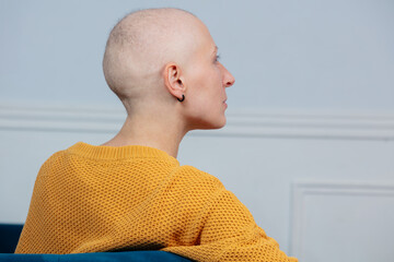 Thoughtful pretty woman with a bald head struggle of cancer