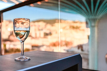 Glass of white wine on table in sunlight. Atmosphere of delightful event.