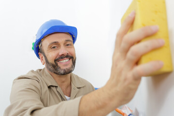 male builder cleaning a wall