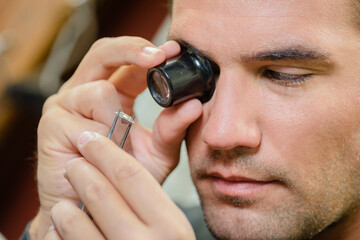 a jeweller looking through magnifier