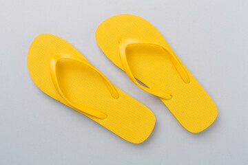 Bright yellow flip-flops on color background, top view. Summer concept