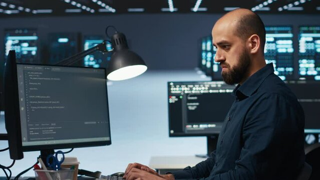 IT engineer overseeing server room, running code on computer, troubleshooting servers. Programmer at work upgrading hardware clusters, networking systems and storage arrays